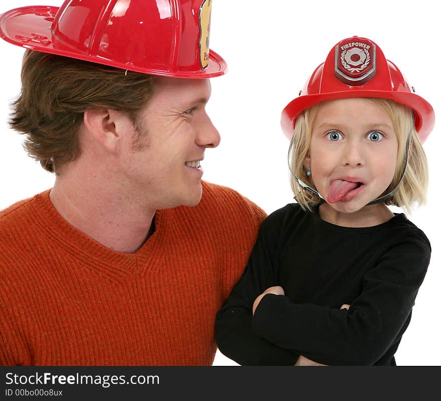 Adorable five year old girl with father. Making faces and wearing fire figher hat. Adorable five year old girl with father. Making faces and wearing fire figher hat.