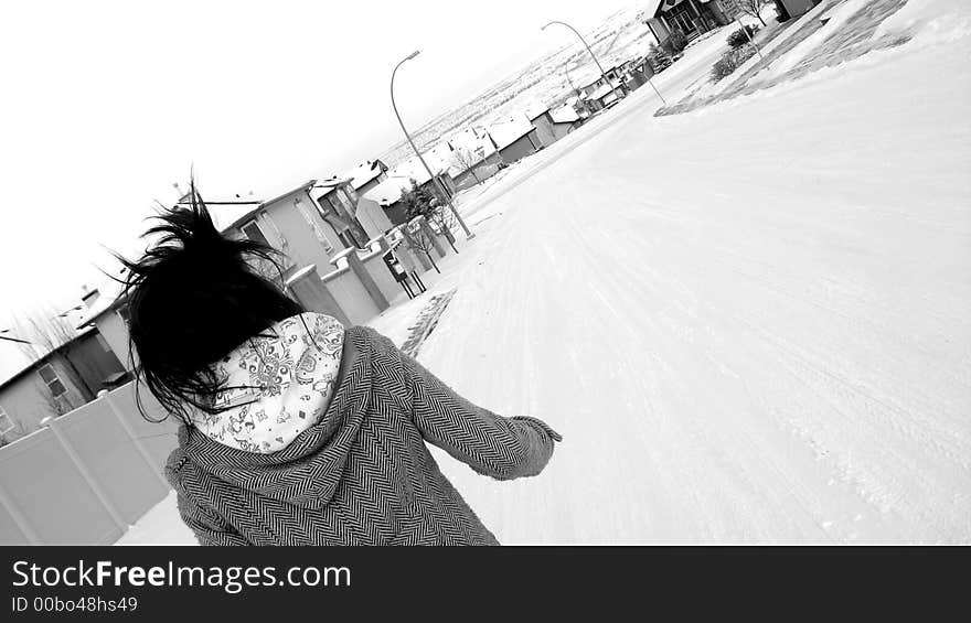 A young woman running down a snow covered street. A young woman running down a snow covered street