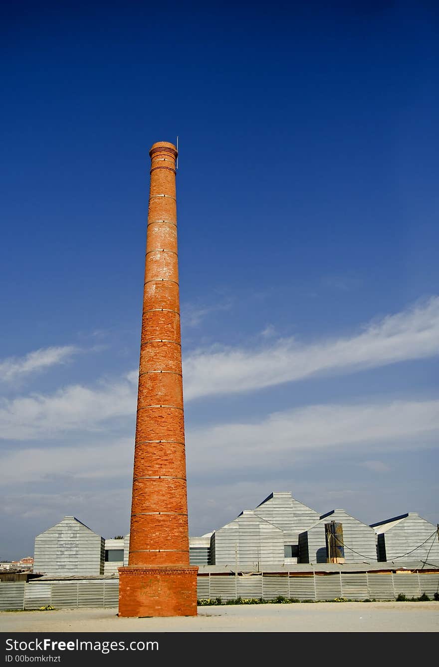 Big red brick chimney with blue sky