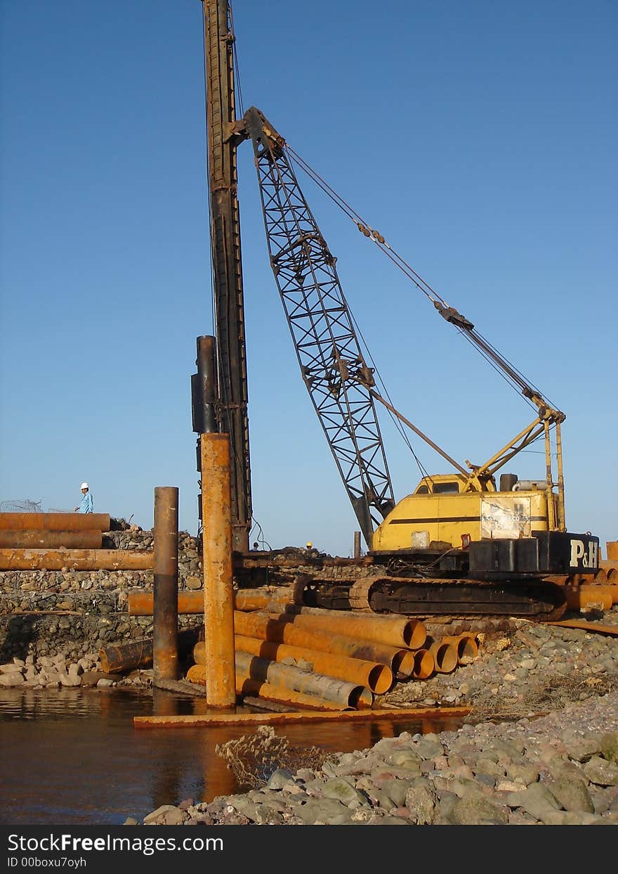 Worker in a jetty operating a crane