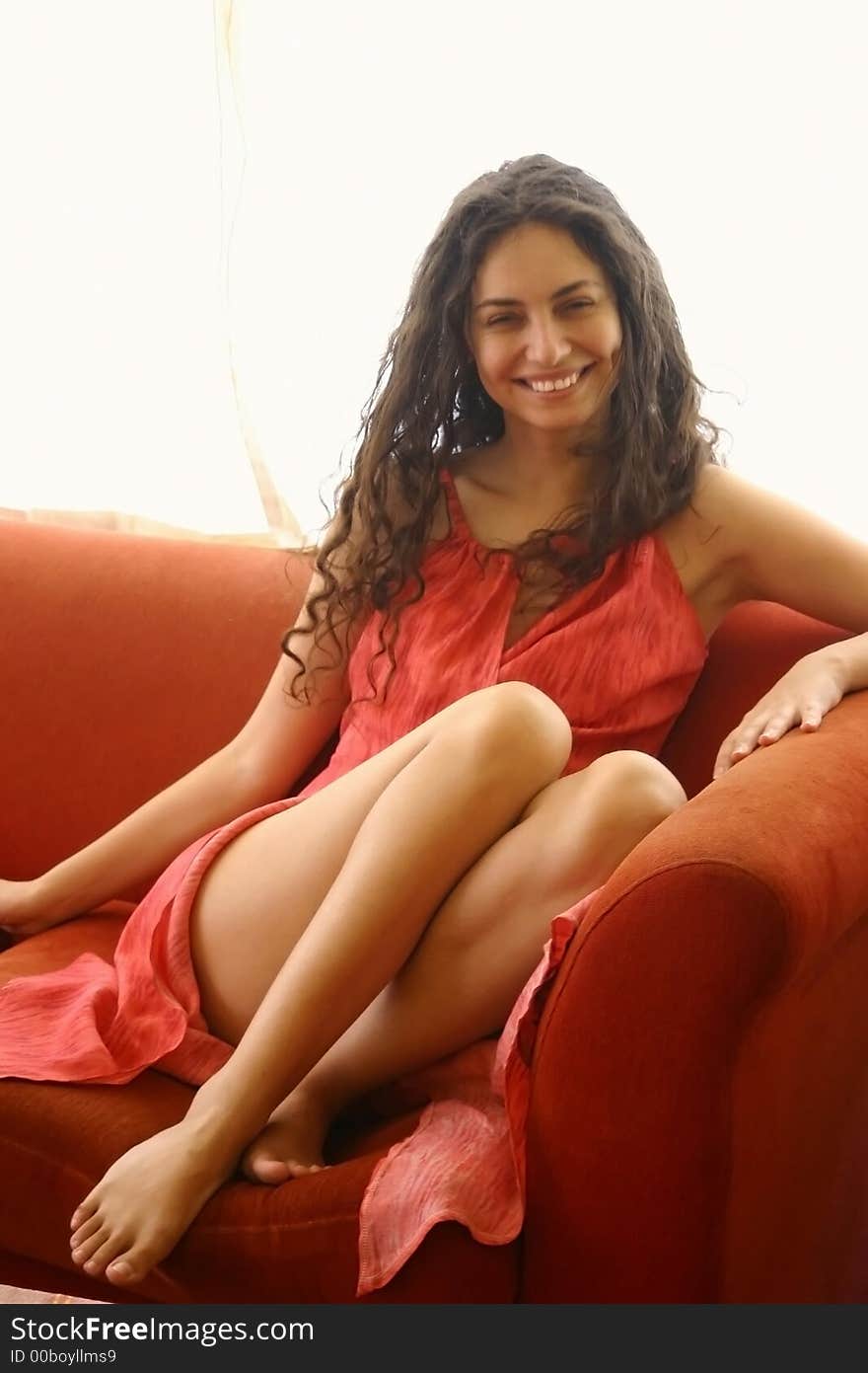 Woman in red dress on a red couch. Woman in red dress on a red couch