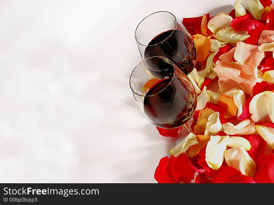 Wine glasses on flower petals for valentines day