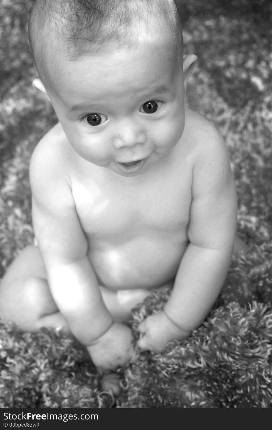 Image of smiling baby boy sitting on a fuzzy blanket