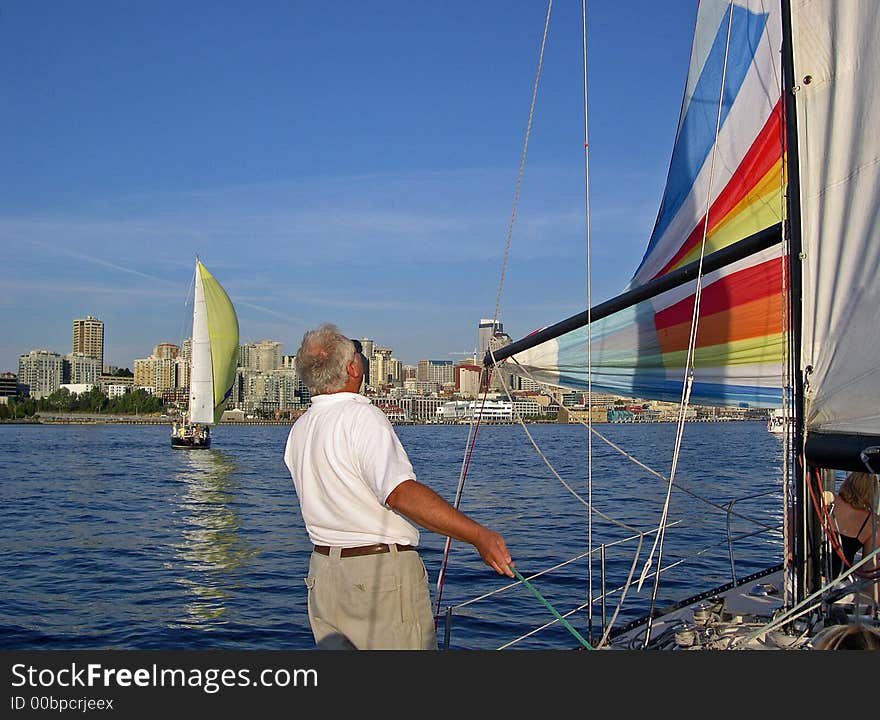 Captain of the sailboat adjusting the spinnaker sail. Captain of the sailboat adjusting the spinnaker sail