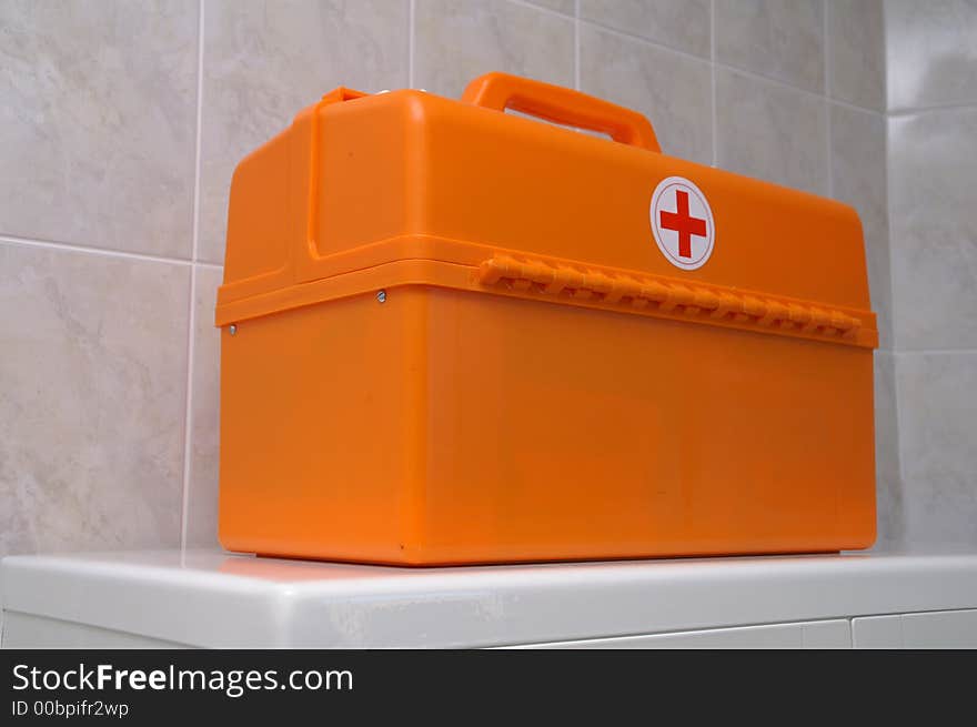 The orange doctors' suitcase on the white table. The orange doctors' suitcase on the white table