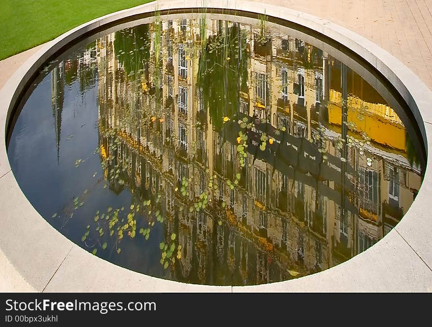 Reflection of hotel in an oval small reservoir in resort city Montreux in Switzerland. Reflection of hotel in an oval small reservoir in resort city Montreux in Switzerland