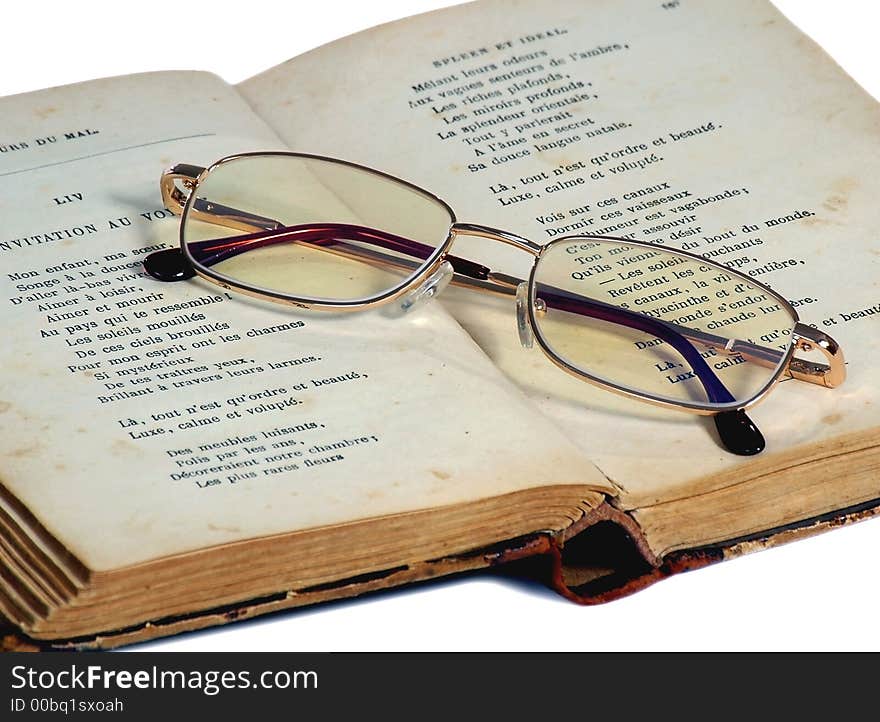 Glasses for reading lie on the exposed old book on a white background