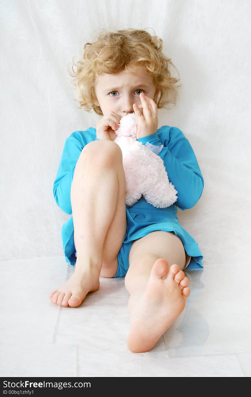 Little blonde curly girl with toy on the white with toy. Little blonde curly girl with toy on the white with toy