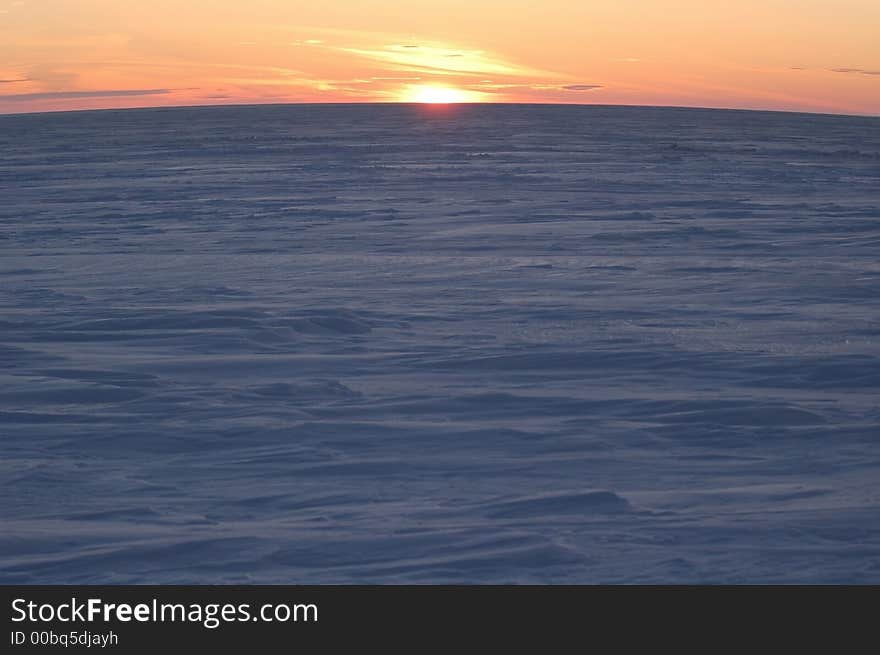 A sunrise is in the north above ice