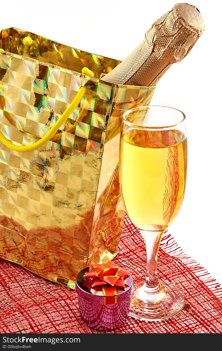 Bottle of a champagne in celebratory packing and glasses with wine