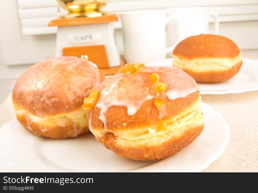 A tasty icing donuts on the plate in the kitchen. A tasty icing donuts on the plate in the kitchen.