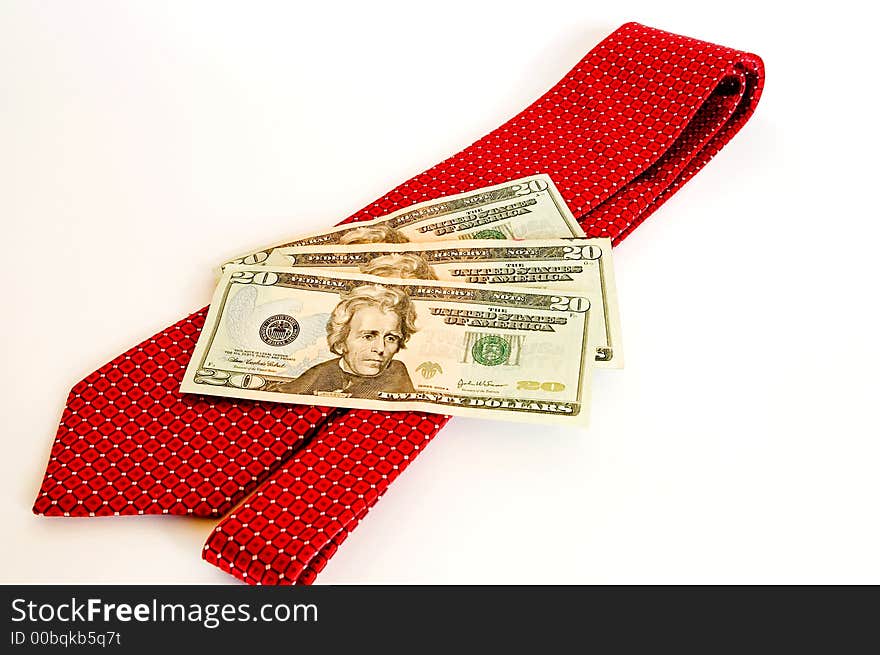 A close up view of a red tie with three twenty dollar bills (US) against a white background. A close up view of a red tie with three twenty dollar bills (US) against a white background.