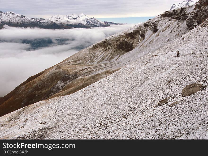 Hiker on the Eiger Trail after first Fall snowfall, The Eiger near Eiger Gletscher, Switzerland