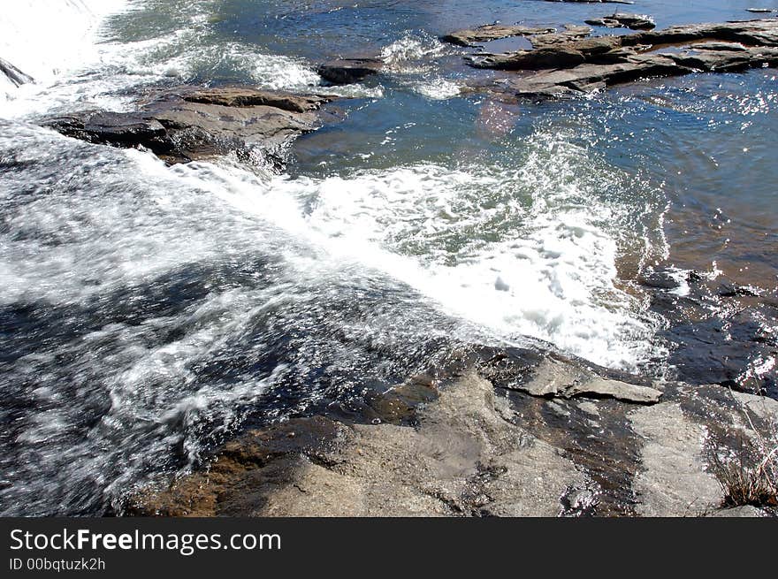 Water running over a dam and over boulders. Water running over a dam and over boulders