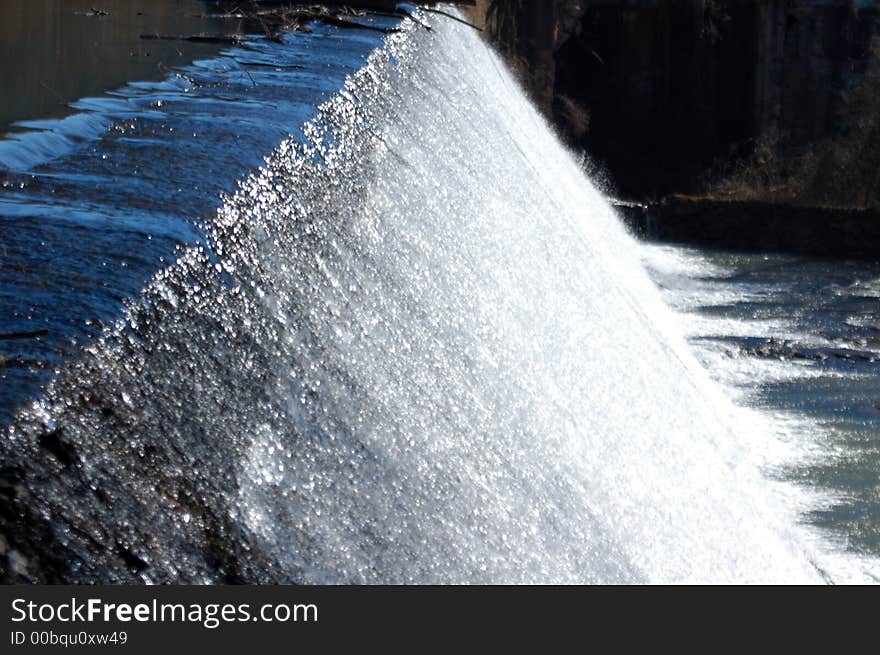 Water running over a dam and over boulders. Water running over a dam and over boulders