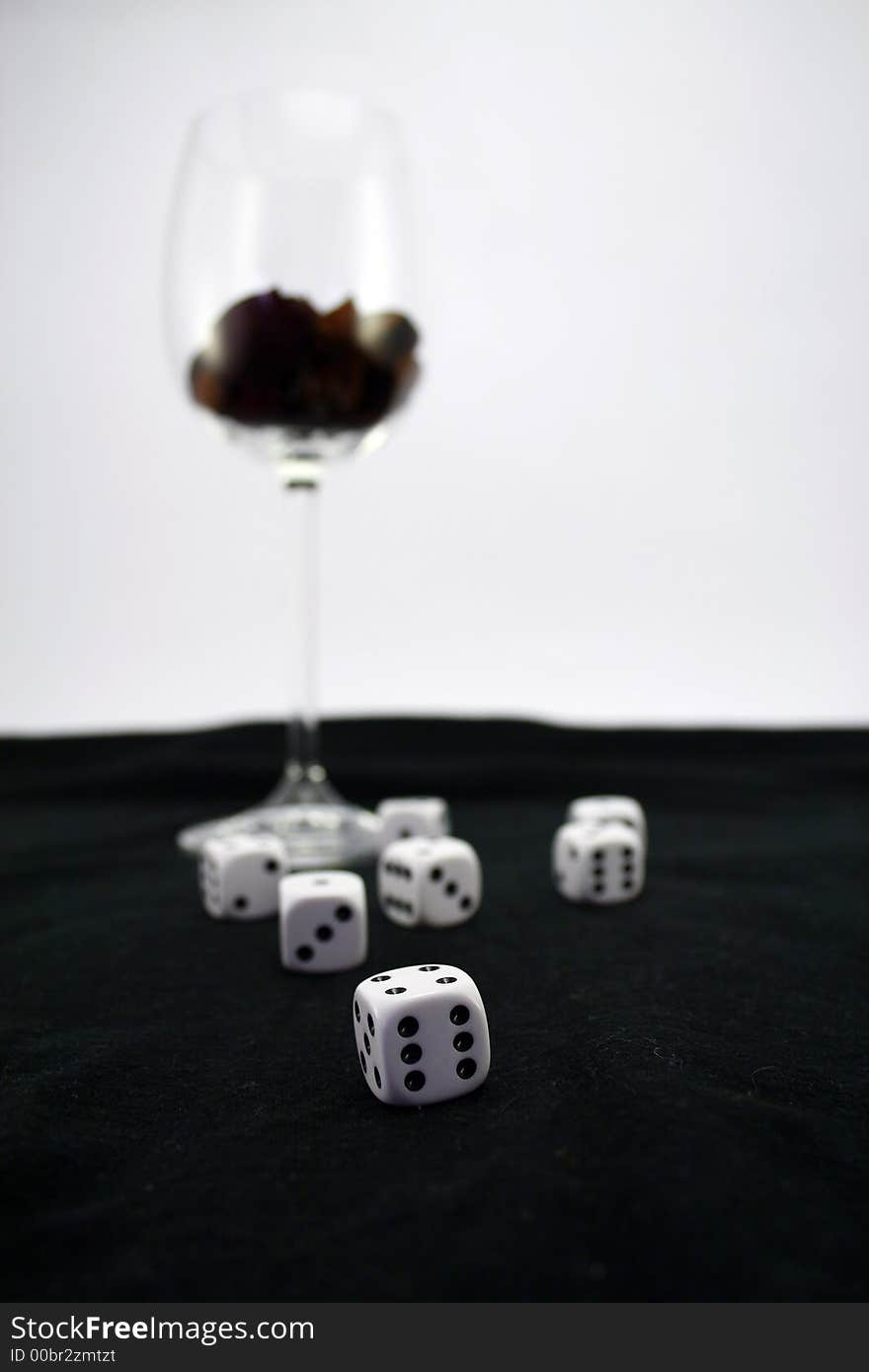 Wine glass on black background with dice. Wine glass on black background with dice