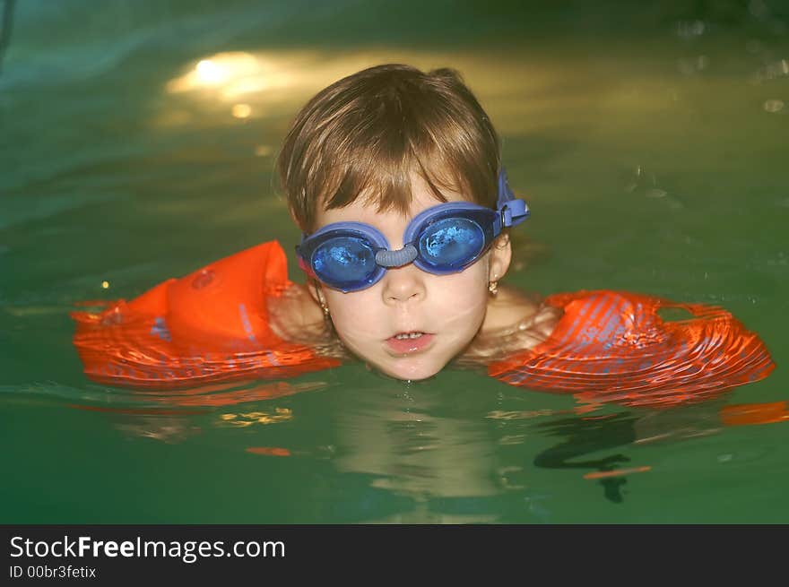 Two and a half year old girl swimming alone in the pool with arm bands. Two and a half year old girl swimming alone in the pool with arm bands.