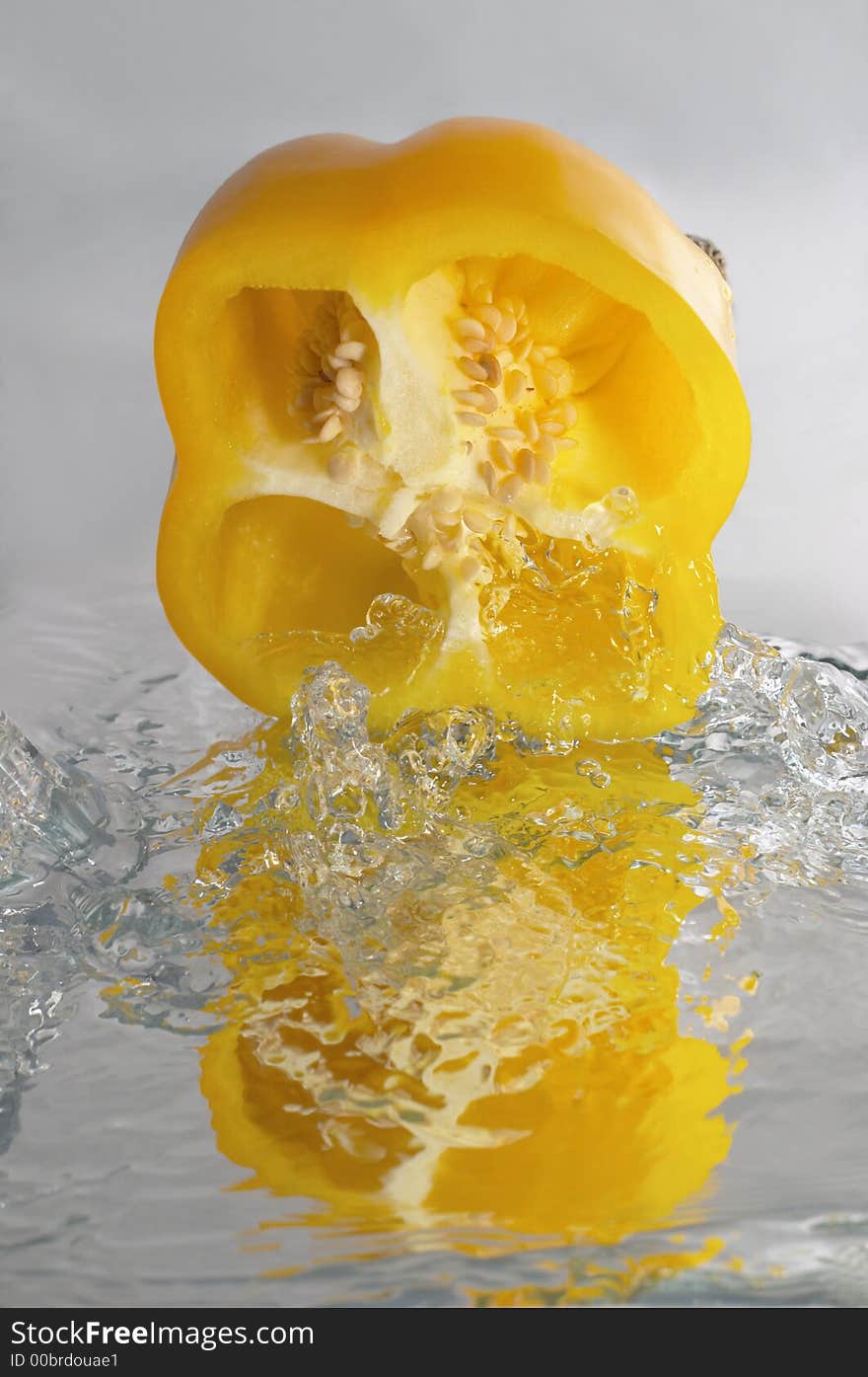 Yellow paprika over mirror in water splashes. Yellow paprika over mirror in water splashes