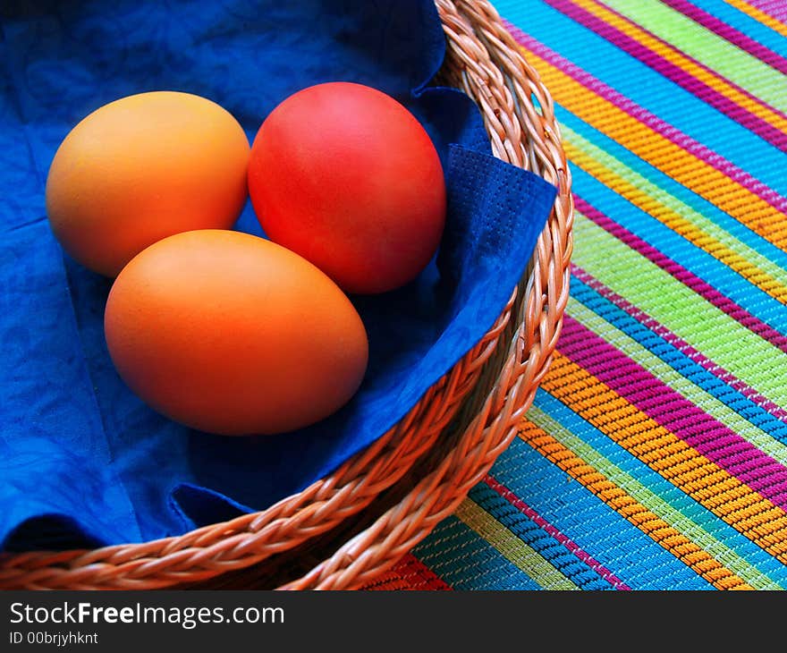 Three eggs in the basket on striped fabric. Three eggs in the basket on striped fabric