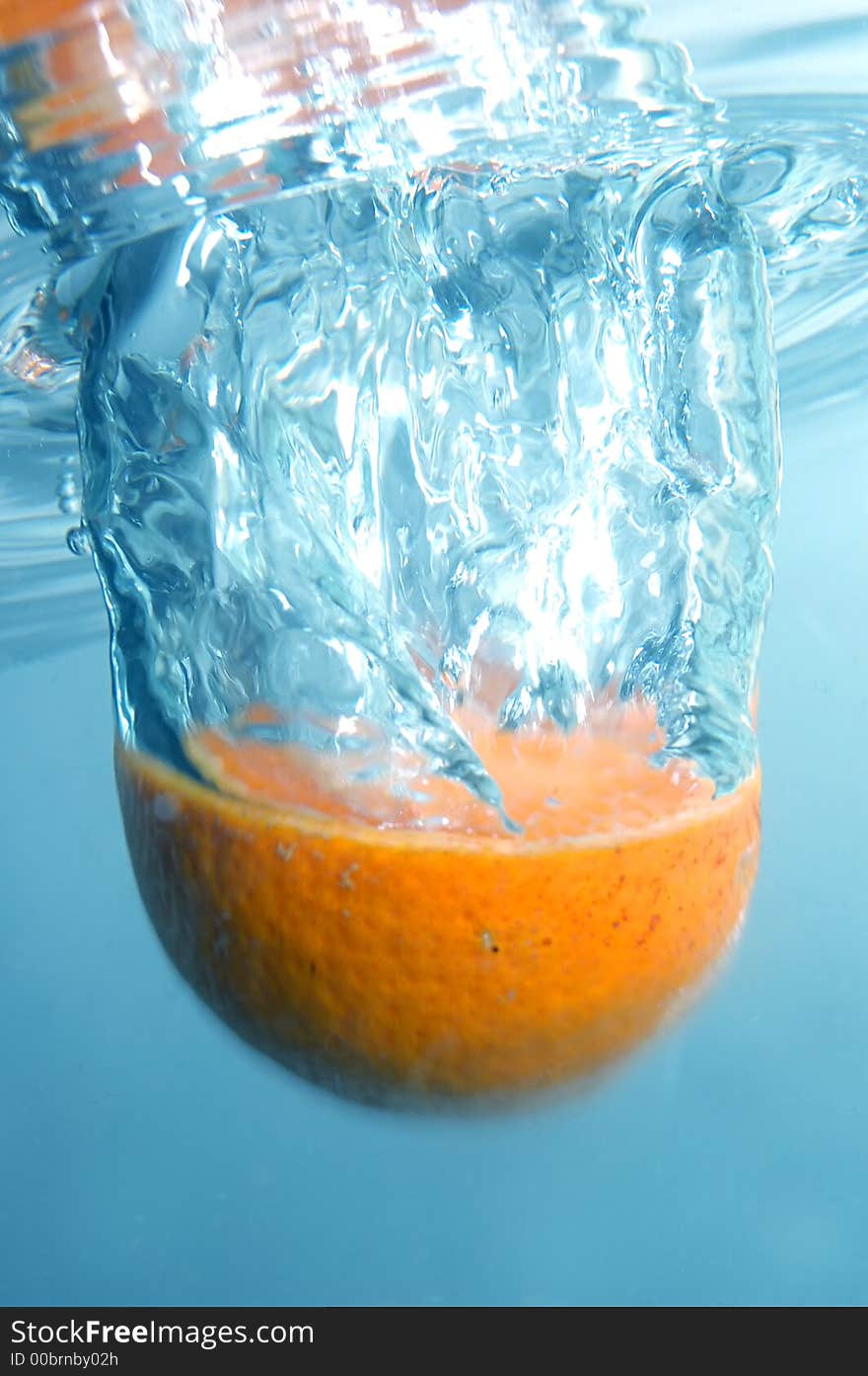 Fresh orange jumping into water with a splash. Little motion blured. Fresh orange jumping into water with a splash. Little motion blured.