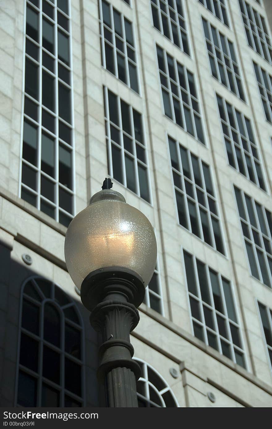 Facade of a modern office building behind a traditional street lamp