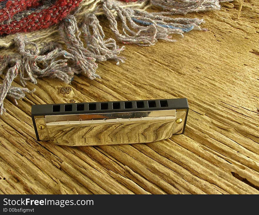 Harmonica on weathered wood with Western-style blanket