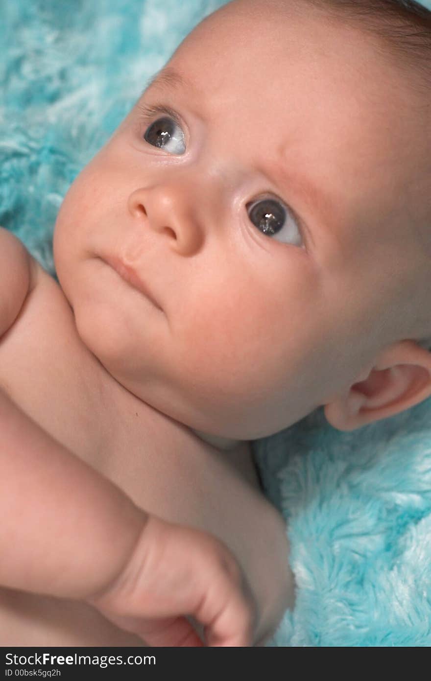 Image of baby boy lying on a fuzzy turquoise blanket. Image of baby boy lying on a fuzzy turquoise blanket