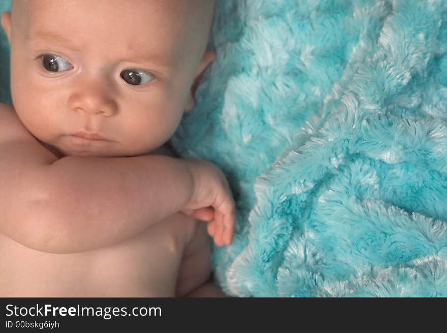 Image of baby boy lying on a fuzzy turquoise blanket. Image of baby boy lying on a fuzzy turquoise blanket