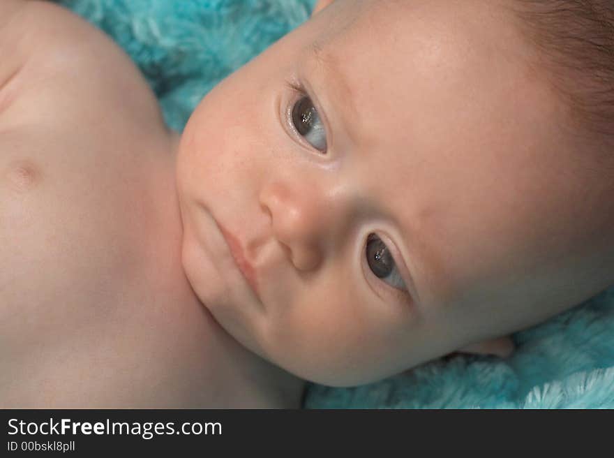 Image of baby boy lying on a fuzzy turquoise blanket. Image of baby boy lying on a fuzzy turquoise blanket