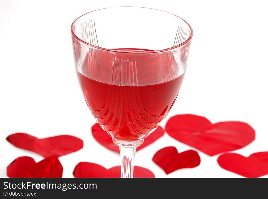 Red glass of wine with red hearts in background