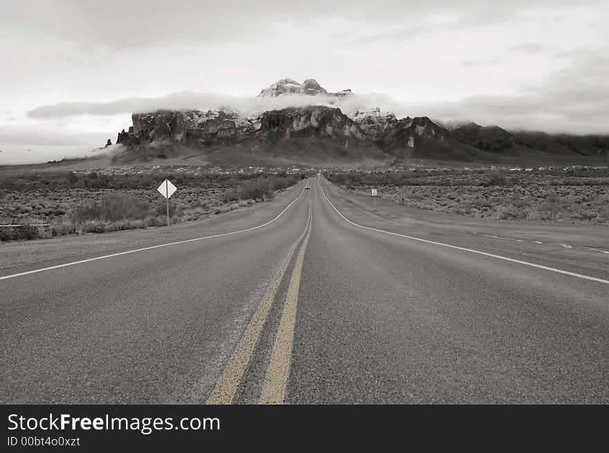 Lonely road on a stormy winter day leading to the Superstition Mountains in Arizona. Lonely road on a stormy winter day leading to the Superstition Mountains in Arizona