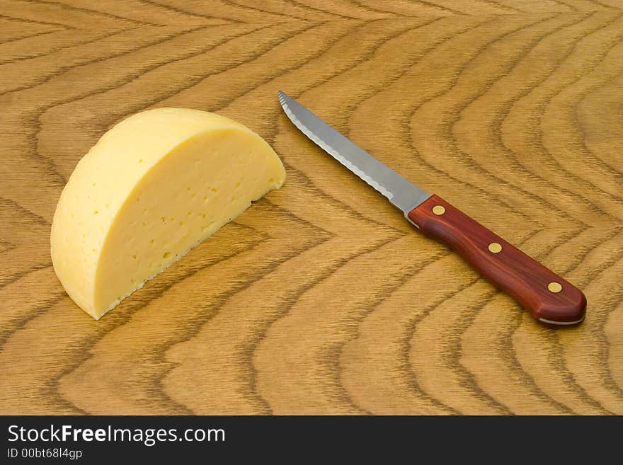 Cheese and knife on wooden table