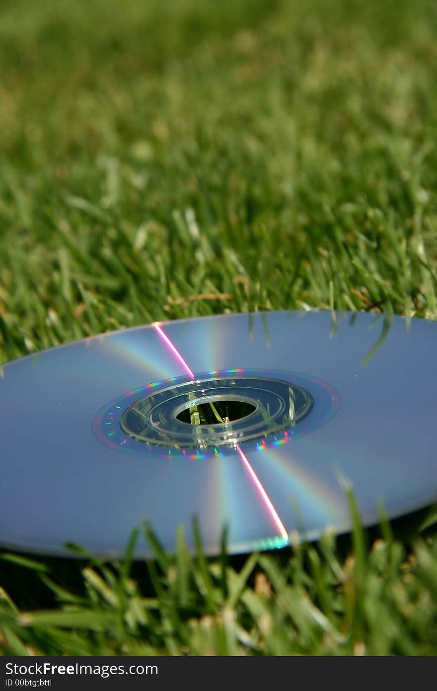 Silver rainbow dvd on green grass outside in the sunshine. Silver rainbow dvd on green grass outside in the sunshine