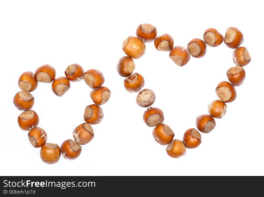 Closeup for little hazelnuts in heart shape isolated on white background