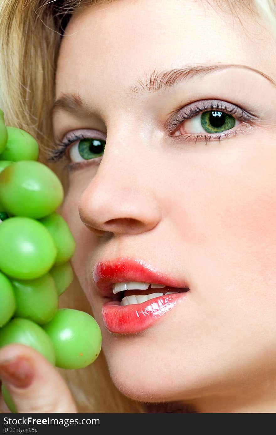 Beautiful young woman with green grape