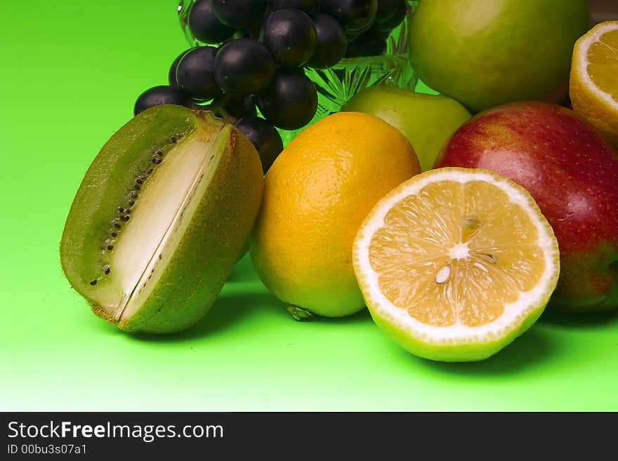 Great number of bright and juicy fruit on a green background