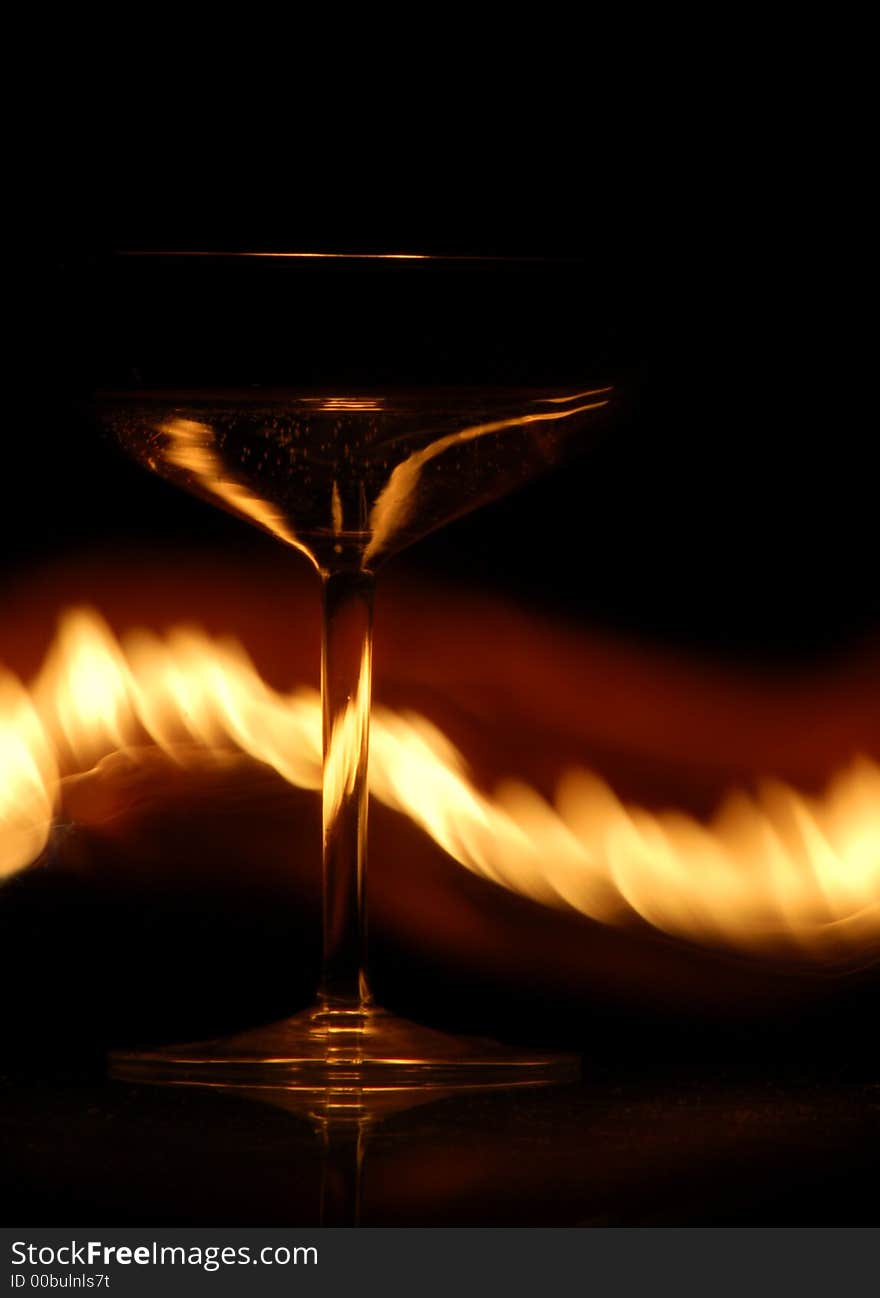 Luxurious wine glass on a glass table with flames. Luxurious wine glass on a glass table with flames.