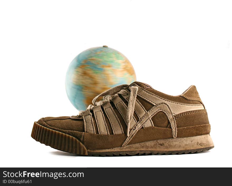 Sport shoes next to a globe on a white background