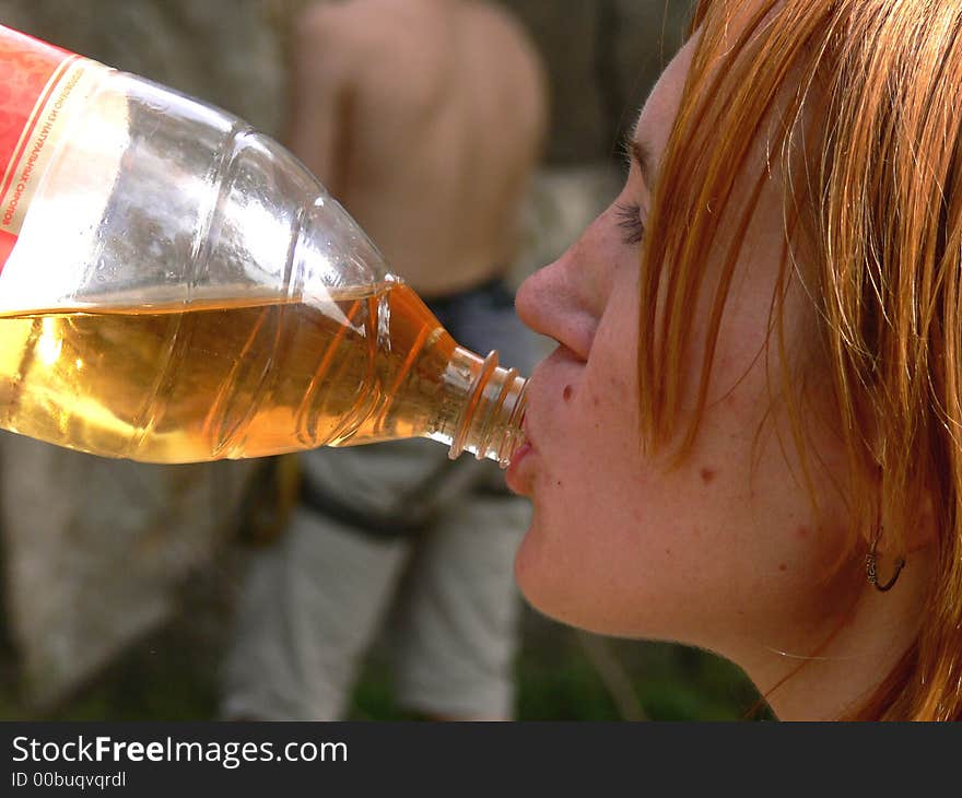 A young girl is drinking a soft drink. A young girl is drinking a soft drink