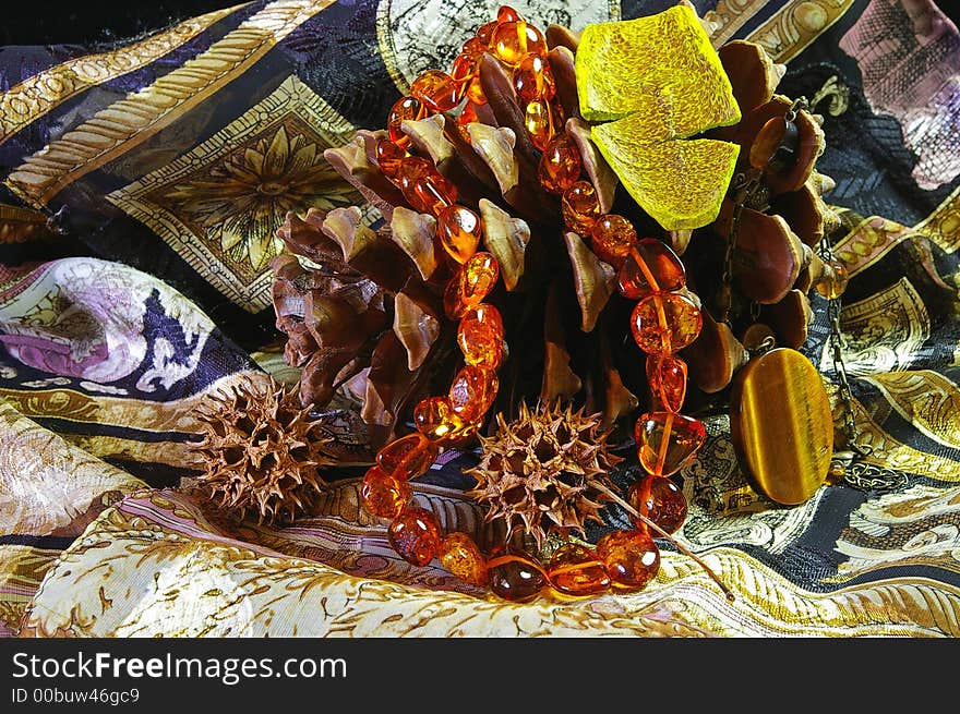 Still life with jewelry on cone and classic silk background