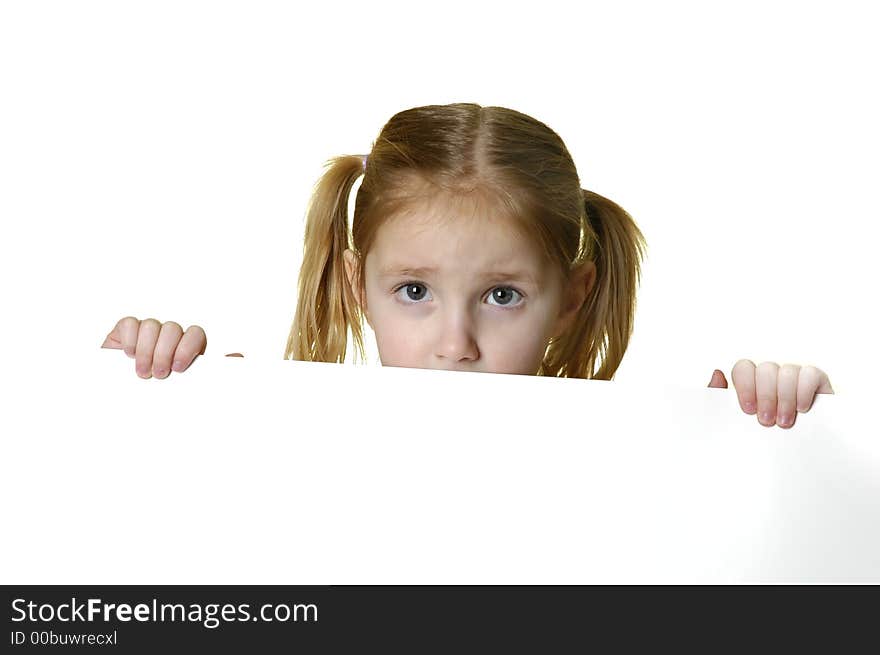 Little girl looking over the edge of a white sign she is holding