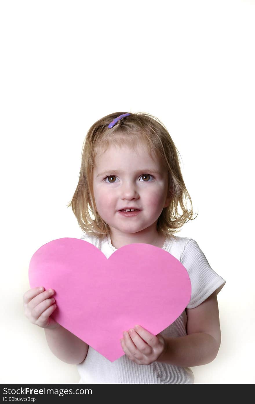 Little girl dressed in white holding a valentine heart. Little girl dressed in white holding a valentine heart