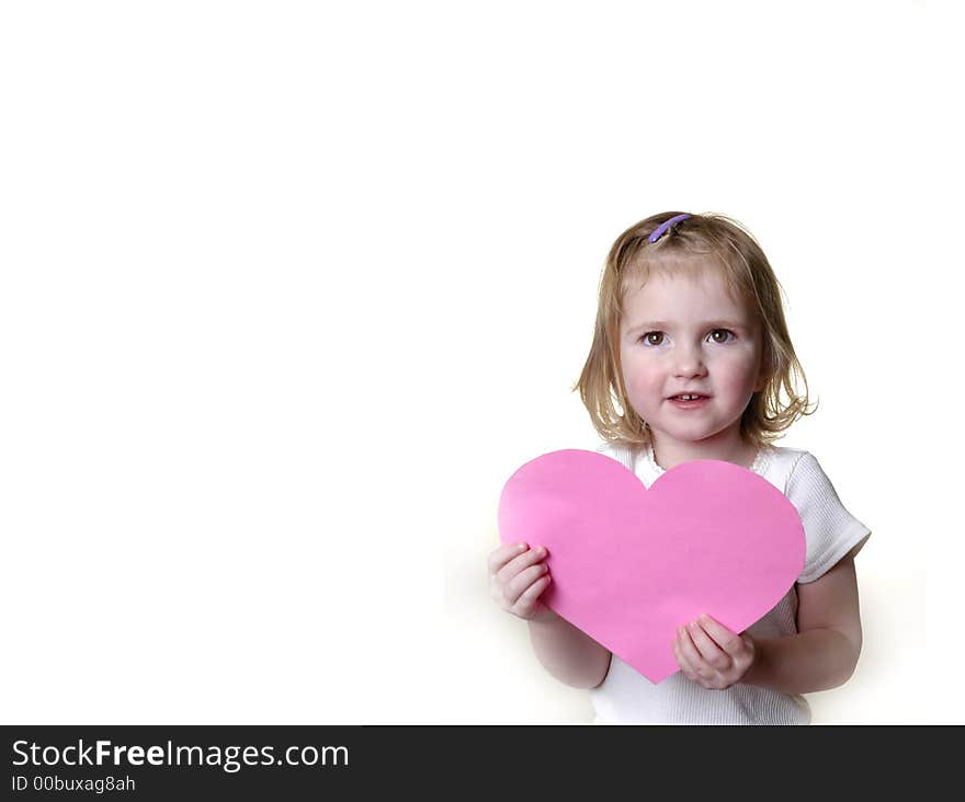 Little girl dressed in white holding a valentine heart. Little girl dressed in white holding a valentine heart