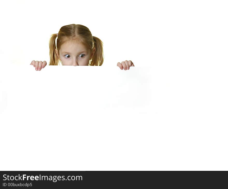 Little girl looking over the edge of a white sign she is holding