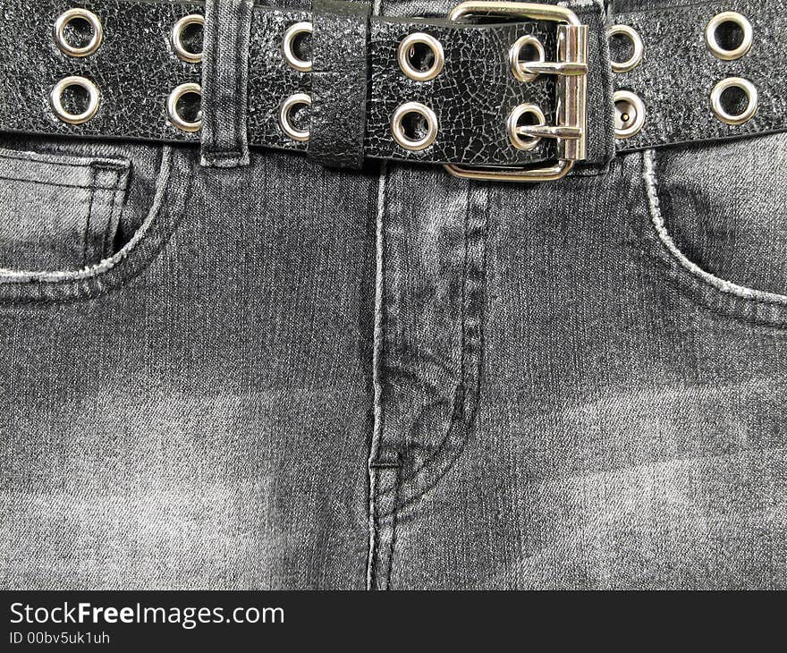 Closeup of black denim jeans with black leather belt and metal buckle. Closeup of black denim jeans with black leather belt and metal buckle.