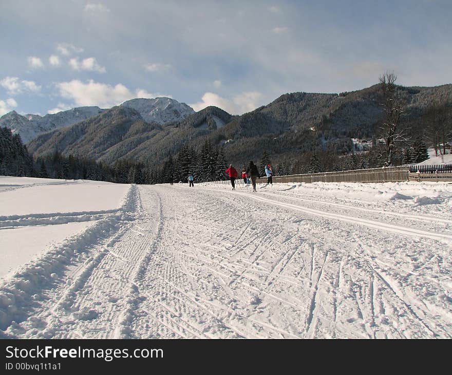 Beautiful winter landscape showing a cross-country ski run with people skiing