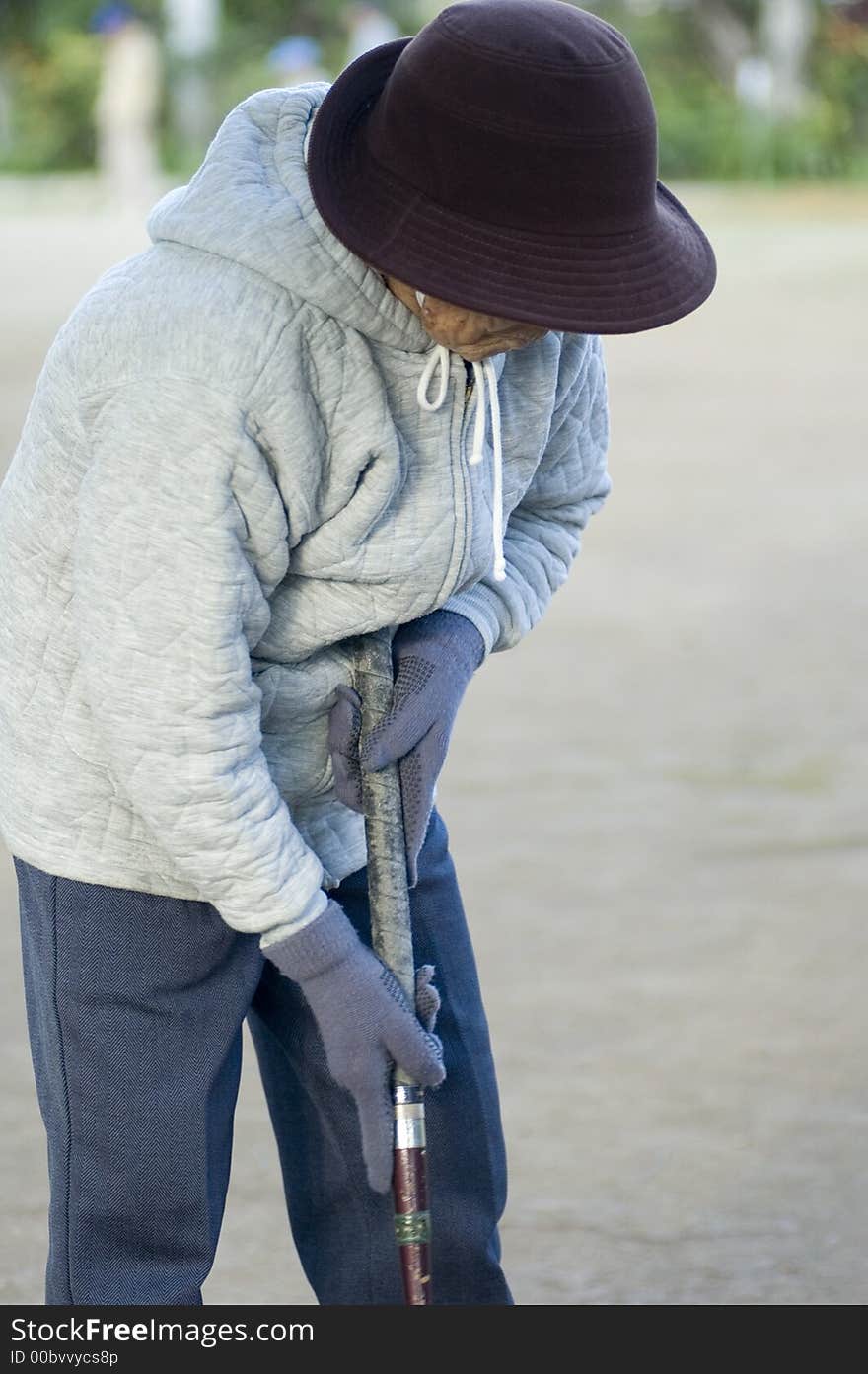 Old Asian woman playing game ball in the cold