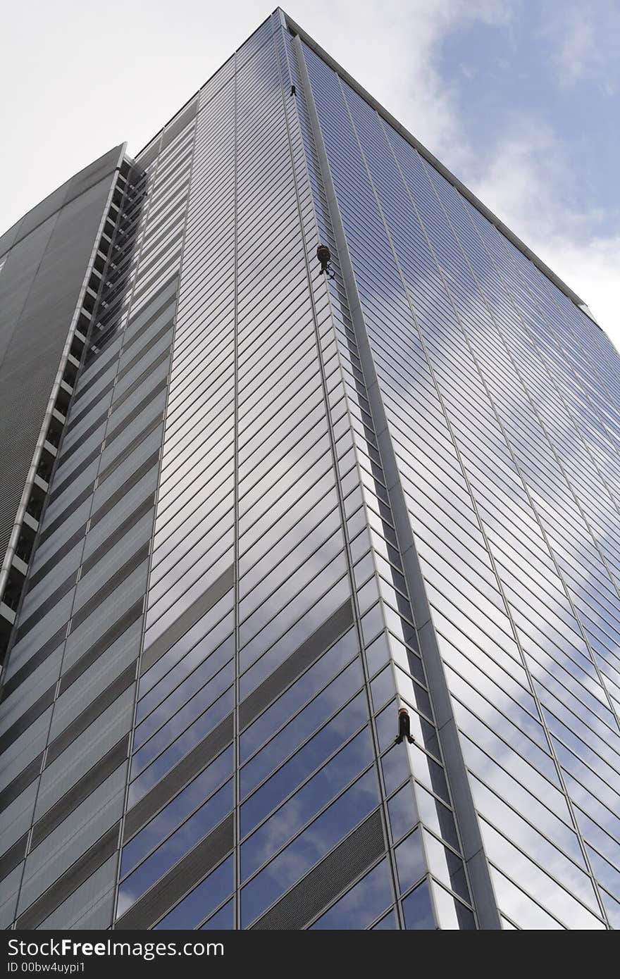 Down-up perspective near a corporate building with sky reflections in the windows. Down-up perspective near a corporate building with sky reflections in the windows