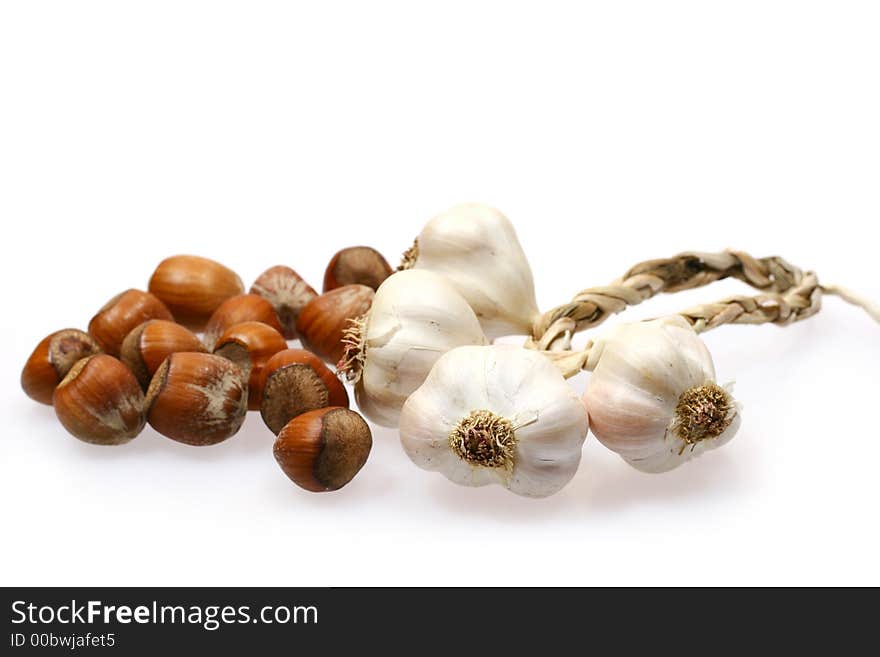 Pieces of garlic and hazelnuts isolated on white background