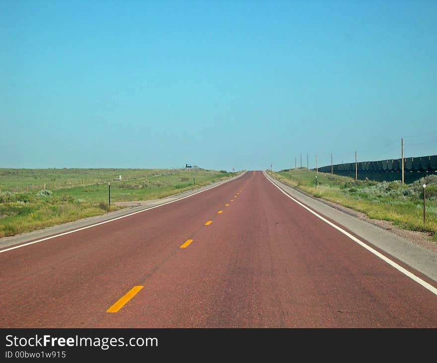 Red pavement heading west through Wyoming State. Red pavement heading west through Wyoming State